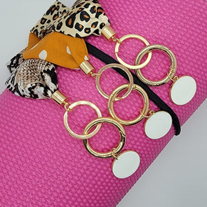 These swank keychains are functional and spirited! Show off your fun personality! No reason to carry your whole purse to class or the gym. Simply slip the soft fabric over your wrist and your keys/key cards/card wallet are at your fingertips in seconds. In addition to the split ring, these key chains also have a detachable key ring, with a tag charm you can personalize, for added convenience.   3 fabrics - Brown snake skin, Mustard white polka dot & Leopard