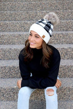 Load image into Gallery viewer, This beanie says, You&#39;ve got it together! This beanie has a white ban that then changes to a black &amp; white plaid with a faux fur pom to top it off. This knit beanie is fleece lined for added warmth too. 
