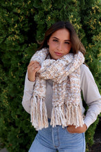 Load image into Gallery viewer, This scarf is ivory/cream based with tan tones mixed throughout and the fringe is absolutely flattering.
