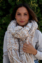 Load image into Gallery viewer, This scarf is ivory/cream based with tan tones mixed throughout and the fringe is absolutely flattering.
