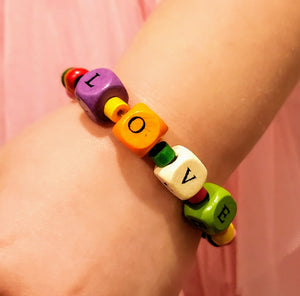 Our young ladies deserve all of the LOVE we can give them! This fun colored wood beaded bracelet has cube beads stamped with LOVE, individually. The LOVE beads are surrounded by colorful tube shaped beads and is completed with beautifully colored round beads.   The bracelets are made of stretch wire and come in sizes 6" & 6-1/2". If you would like a different size, please contact us.  *** Please note that the colors are random with regards to all of the bead types. ***