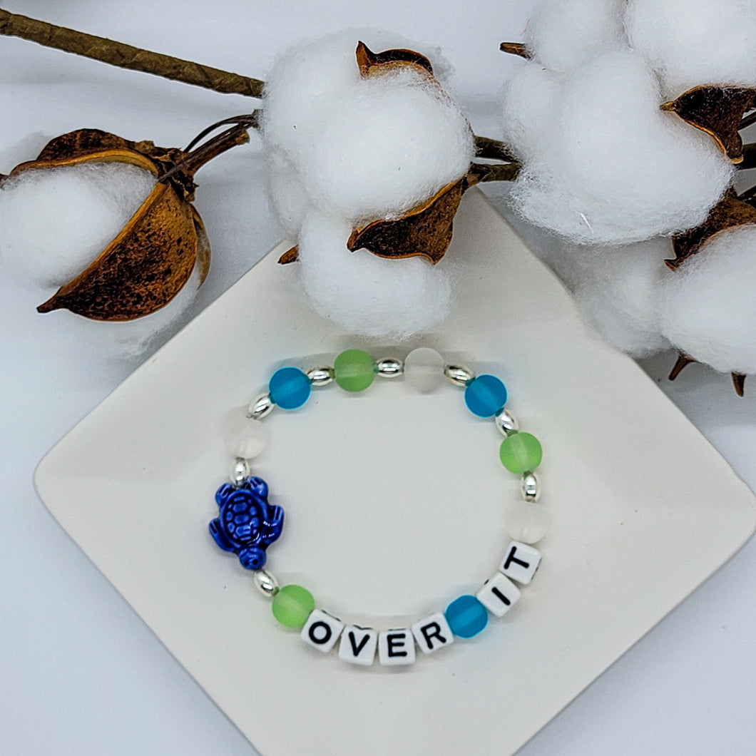 This bright, turtle inspired, Over it stretch bracelet is made with blue, white & green glass beads with silver accent beads. The message is clear and the bracelet is inspirational.