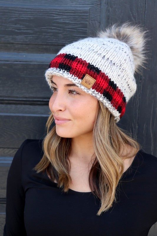 100% cable knit soft acrylic ivory base multi color beanie with red plaid band and a faux fur pom