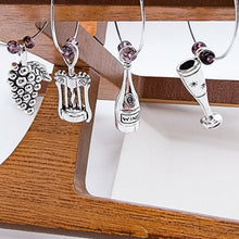 Load image into Gallery viewer, What goes around (the wine glass stem) Comes around!  You can&#39;t deny that old school charm is sometimes just what you need. These classic jingly wine charms may bring a bit of nostalgia to your gathering. Silver plated rings with beads accenting various antique wine tasting charms.  Set of 8 charms. 2 different sets to choose from.
