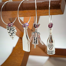 Load image into Gallery viewer, What goes around (the wine glass stem) Comes around!  You can&#39;t deny that old school charm is sometimes just what you need. These classic jingly wine charms may bring a bit of nostalgia to your gathering. Silver plated rings with beads accenting various antique wine tasting charms.  Set of 8 charms. 2 different sets to choose from.
