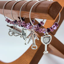 Load image into Gallery viewer, What goes around (the wine glass stem) Comes around!  You can&#39;t deny that old school charm is sometimes just what you need. These classic jingly wine charms may bring a bit of nostalgia to your gathering. Silver plated rings with beads accenting various antique wine tasting charms.  Set of 8 charms. 2 different sets to choose from.
